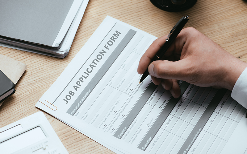 View of man filling in Job Application Form Employment Career Concept